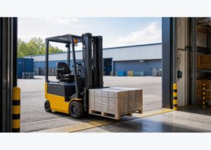 Electric forklift positioned at a warehouse doorway for indoor and outdoor transfer work