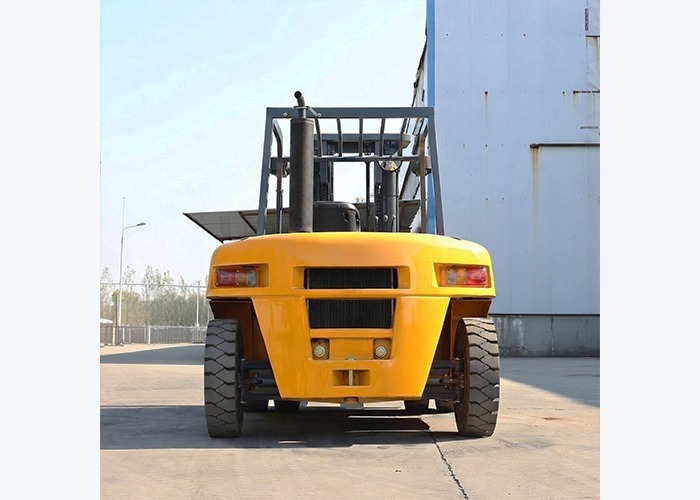 Diesel forklift carrying heavy pallet loads across an outdoor handling area