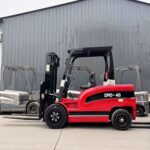 Electric forklift staged beside a charging point for charger compatibility planning